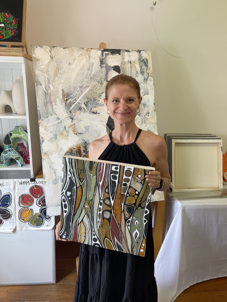 A participant holding her finished work after a workshop session
